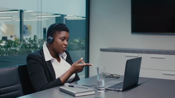 Reunión en línea. Empresaria afroamericana haciendo videollamada en el ordenador portátil en la oficina — Vídeos de Stock