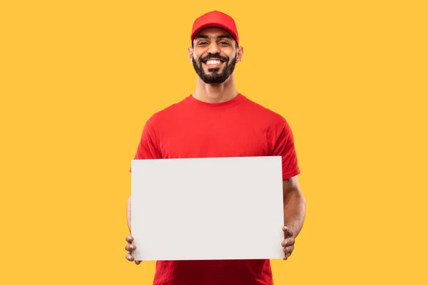 Oriente Medio mensajero individuo mostrando tablero de papel sobre fondo amarillo, burla — Foto de Stock