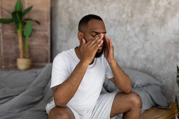Homme noir souffrant de maux de tête ou de migraine au lit — Photo
