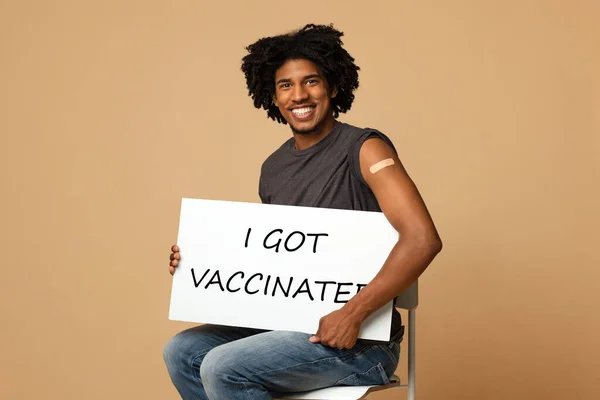 Covid-19 Vaccination. Glad svart kille som håller i skylten med Jag fick vaccinerad text — Stockfoto