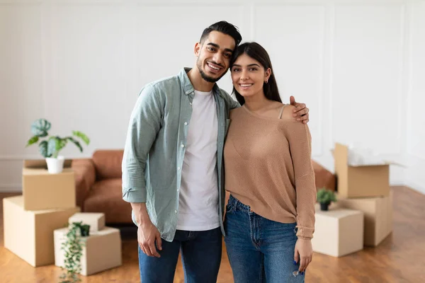 Szczęśliwy mężczyzna i kobieta przytulają się pozując w swoim nowym mieszkaniu — Zdjęcie stockowe
