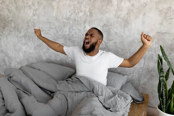 Sleepy joven afroamericano bostezo estiramiento después de despertar — Foto de Stock