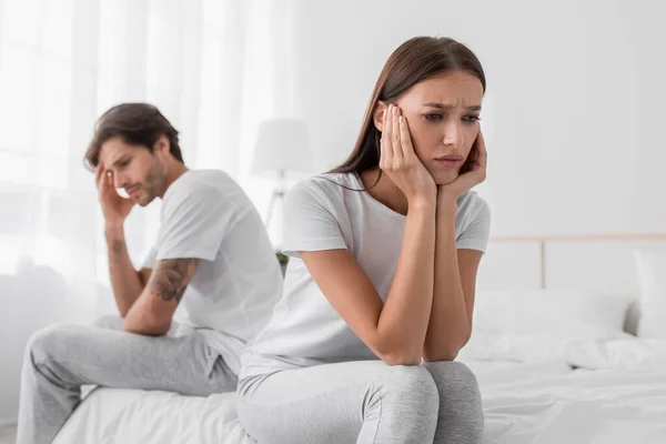 Depressieve duizendjarige Europese vrouw zit op bed, negeert beledigde man in slaapkamer interieur — Stockfoto