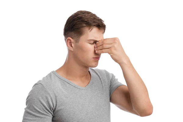 Despaired sad millennial european male presses hand to nose, suffers from migraine or runny nose — Stock Photo, Image