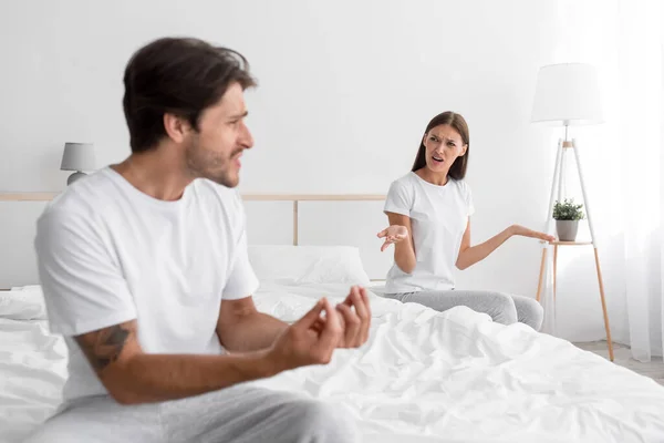 Emocional enojado emocionado joven caucásico hombre y esposa juran, gritar y asustarse en el interior del dormitorio —  Fotos de Stock