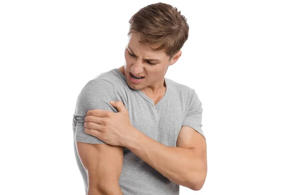 Despaired sad millennial caucasian attractive man presses his hand to sore spot and suffers from shoulder pain — Stock Photo, Image