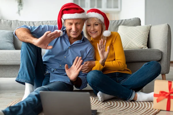 自宅でクリスマスにビデオ通話を行う楽しいシニアカップル — ストック写真