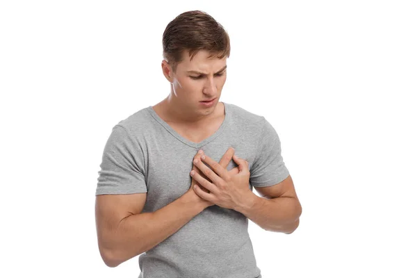 Chocado triste milenar europeu bonito homem pressiona as mãos para ponto dolorido e sofre de dor no peito — Fotografia de Stock