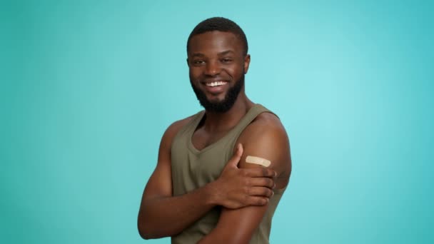 Концепция вакцинации. Счастливый чернокожий парень, стреляющий с клеймом после инсульта — стоковое видео