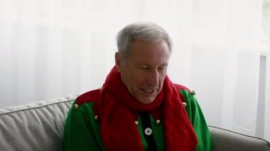 Grip mevsimi. Evde Hapşıran Noel Elf kostümü giyen son sınıf öğrencisi.