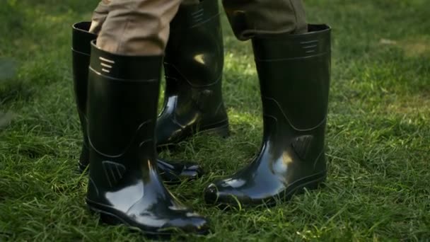 Primer plano de pareja irreconocible bailando en botas de goma al aire libre en el jardín — Vídeo de stock