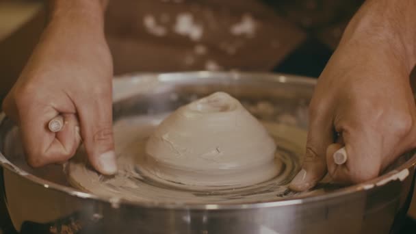 Невпізнаваний Гончар, користуючись знаряддями для кераміки, працює з глиною в приміщенні — стокове відео