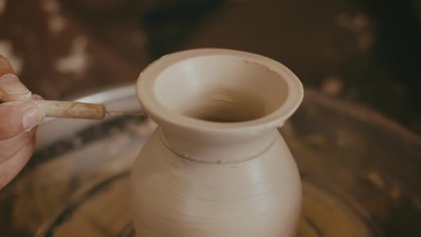 Поттер виготовляє керамічну вазу за допомогою керамічних інструментів у приміщенні, крупним планом — стокове відео