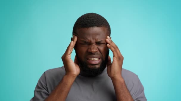 Acute Migraine Concept. Zieke zwarte man lijden hoofdpijn, het masseren van zijn tempels — Stockvideo