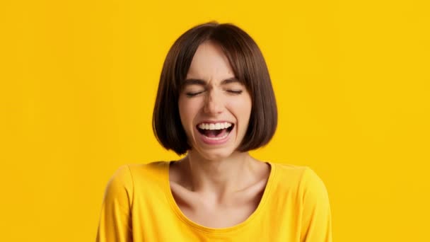 Millennial θηλυκό γέλιο έξω Loud Posing στέκεται πάνω από κίτρινο φόντο — Αρχείο Βίντεο