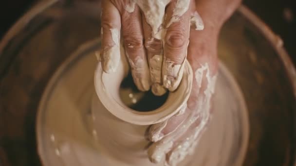 Argilla modellante del vasaio con le mani sulla ruota della ceramica, primo piano, vista dall'alto — Video Stock