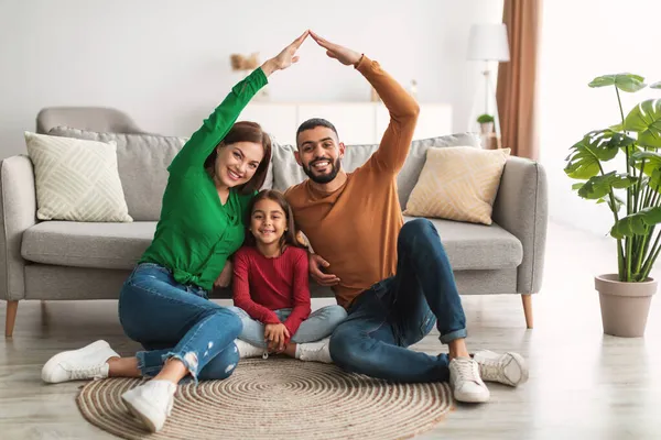Lyckliga föräldrar gör symboliska tak över händerna över sin dotter — Stockfoto