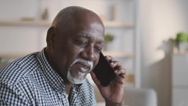 Conversación móvil. Hombre afroamericano mayor hablando por celular, disfrutando de la comunicación mundial en casa, espacio vacío — Vídeos de Stock
