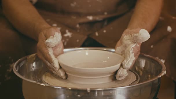 Felismerhetetlen Potter kézműves Alakító agyag lemez dolgozik a kerék beltéri — Stock videók