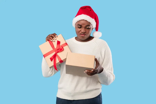 Niezadowolony Afryki Lady otwarcie złe Boże Narodzenie prezent na niebieskim tle — Zdjęcie stockowe