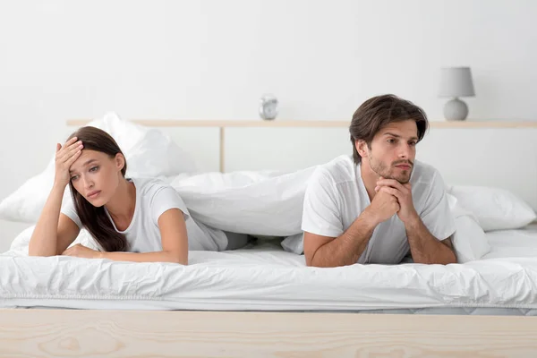 Infeliz molesto ofendido enojado millennial europeo esposa y marido acostado en la cama, ignorando pareja —  Fotos de Stock