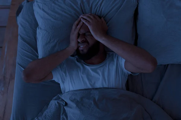 밤에 두 통이나 편두통으로 고생하는 흑인 남자 — 스톡 사진