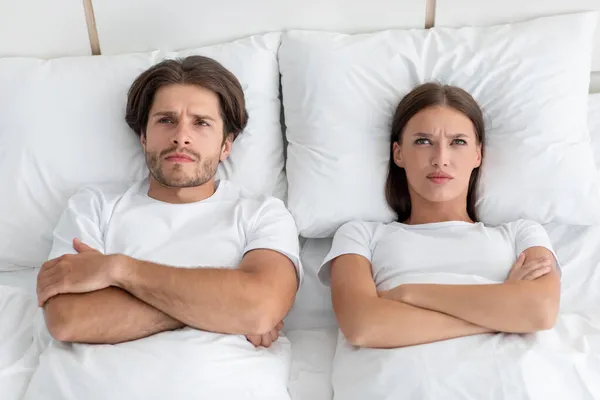 Malheureux offensé triste en colère millénaire caucasien mari et femme avec les bras croisés sur la poitrine se trouvent au lit blanc — Photo