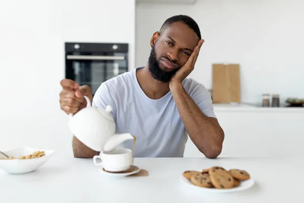 Zwarte man gieten koffie weg van kopje morsen warme drank — Stockfoto