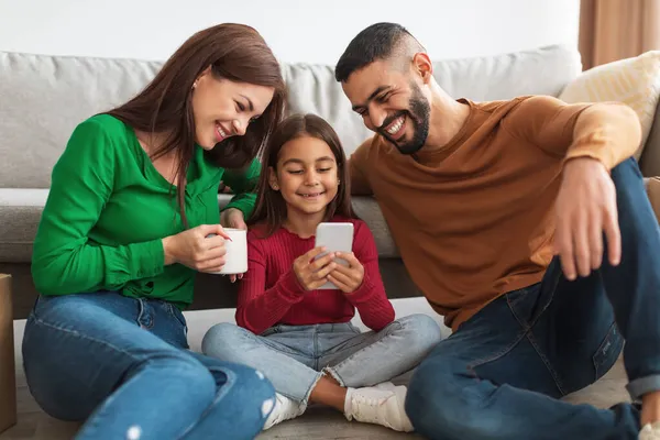 Χαρούμενη Αραβική οικογένεια των τριών ατόμων που κατέχουν και χρησιμοποιούν smartphone — Φωτογραφία Αρχείου
