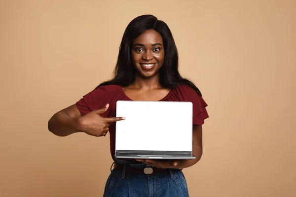Mulher americana africana bonita apontando para laptop com tela vazia — Fotografia de Stock