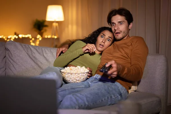 Geschocktes Paar schaut gruseligen Horrorfilm im heimischen Fernsehen — Stockfoto