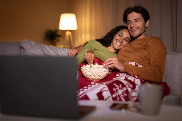 Ζευγάρι Απολαμβάνοντας την παραμονή των Χριστουγέννων βλέποντας ταινίες Χριστούγεννα σε απευθείας σύνδεση στο σπίτι — Φωτογραφία Αρχείου