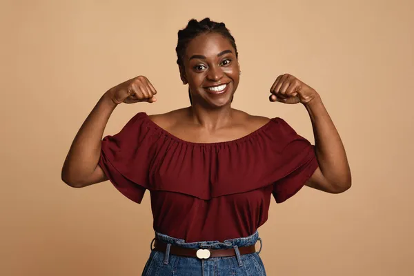 Сильная африканская американка демонстрирует свои мускулы — стоковое фото