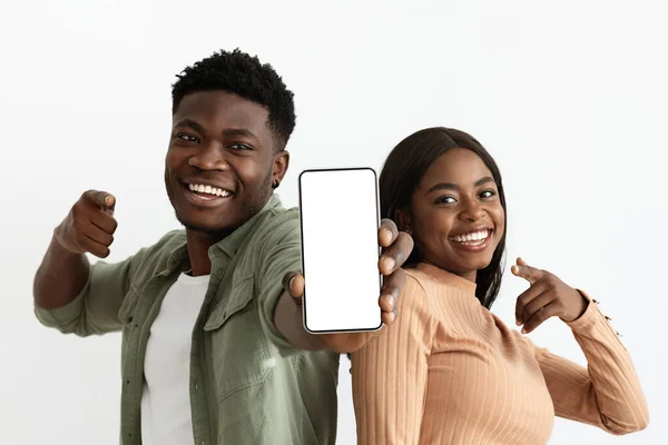Красиві афроамериканські коханці показують мобільний телефон, макет — стокове фото