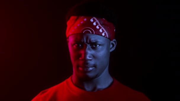 アフリカ系アメリカ人の男は暗いスタジオで頭を振るポーズ — ストック動画