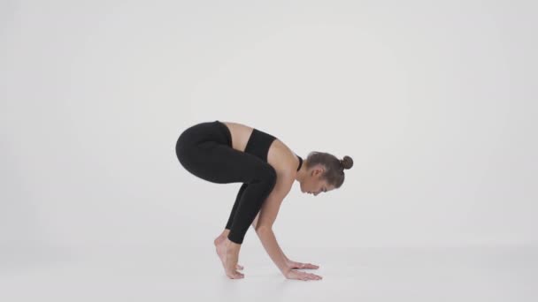 Yoga para pessoas avançadas. Jovem mulher esportiva forte em pé em suas mãos, levantando o corpo e equilibrando — Vídeo de Stock