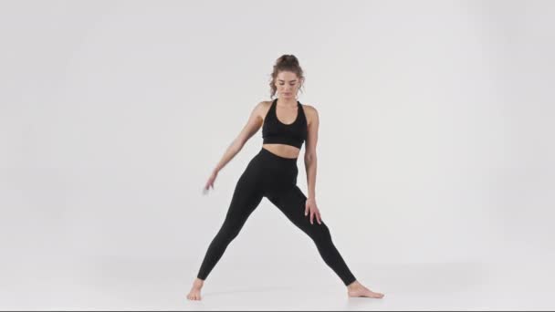 Yoga tutorial. Full length shot van jonge sportieve vrouw oefenen Trikonasana over witte studio achtergrond — Stockvideo