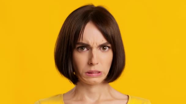 Porträtt av kvinna Grimacing Uttrycka avsky rinnande näsa, gul bakgrund — Stockvideo