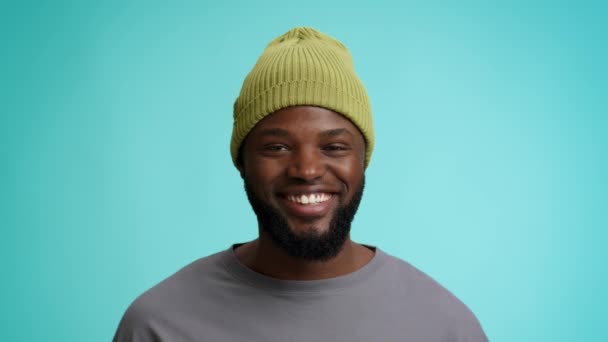 Retrato de bonito jovem preto cara no verde chapéu sorrindo para câmara — Vídeo de Stock