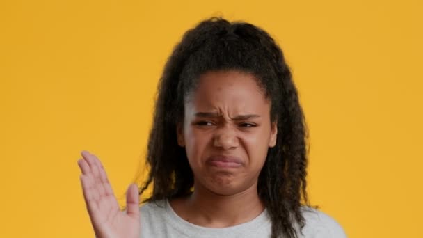 Dégoûté noir adolescent fille pincer nez agitant la main, jaune fond — Video