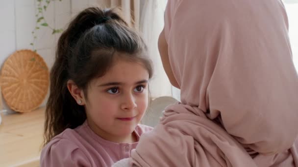 Filha muçulmana abraçando a mãe e tocando Hijab ligação na cozinha — Vídeo de Stock