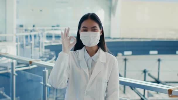 Asiatique femme technicien gestuelle ok porter visage masque dans l'usine — Video