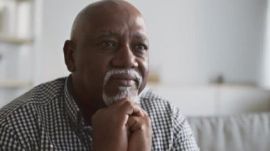 Huzurlu, yaşlı, Afrikalı Amerikalı bir adamın yakın portresi boş alana bakıyor.