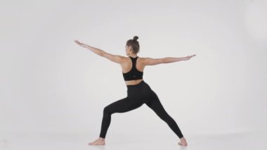 Yoga pratiği. Tanımlanamayan esnek kadının Trikonasana yaparken ve elleriyle kilit yaparken arkadan çekilen görüntüsü.