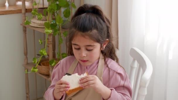 Arab kislány eszik szendvicset, ebédel a konyhában. — Stock videók