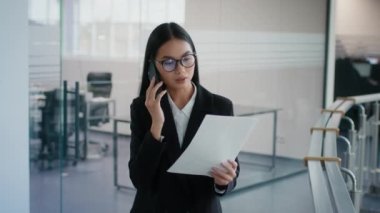 Çinli İş Kadını Ofiste Yürüyen Kağıtları Cep Telefonu ile Konuşuyor