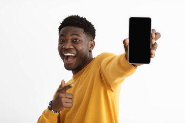 Neşeli siyah adam boş ekran ile akıllı telefon gösteriyor