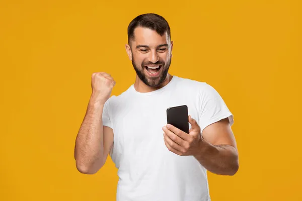 Tevreden tevreden volwassen Europese man die zich euforisch voelt, geniet van een goede boodschap en online overwinning — Stockfoto