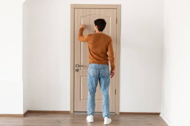Arkadan bakınca ahşap kapıyı çalan adamı görüyorum.