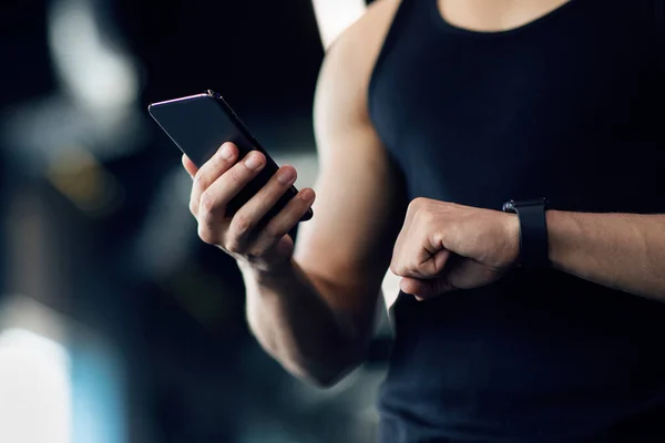 Чоловік спортсмен Використовуючи Smartwatch і додаток для фітнесу на смартфон для моніторингу продуктивності — стокове фото